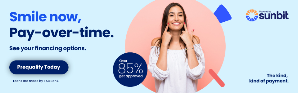 Woman smiling in dental office promoting flexible payment plans for dental services.